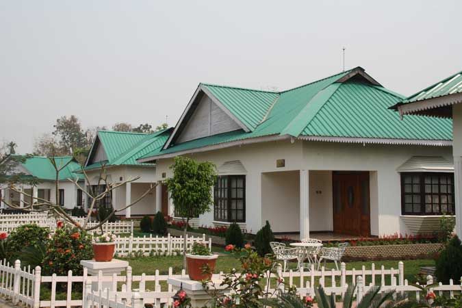 Row of emerald-roofed cottages with rose beds