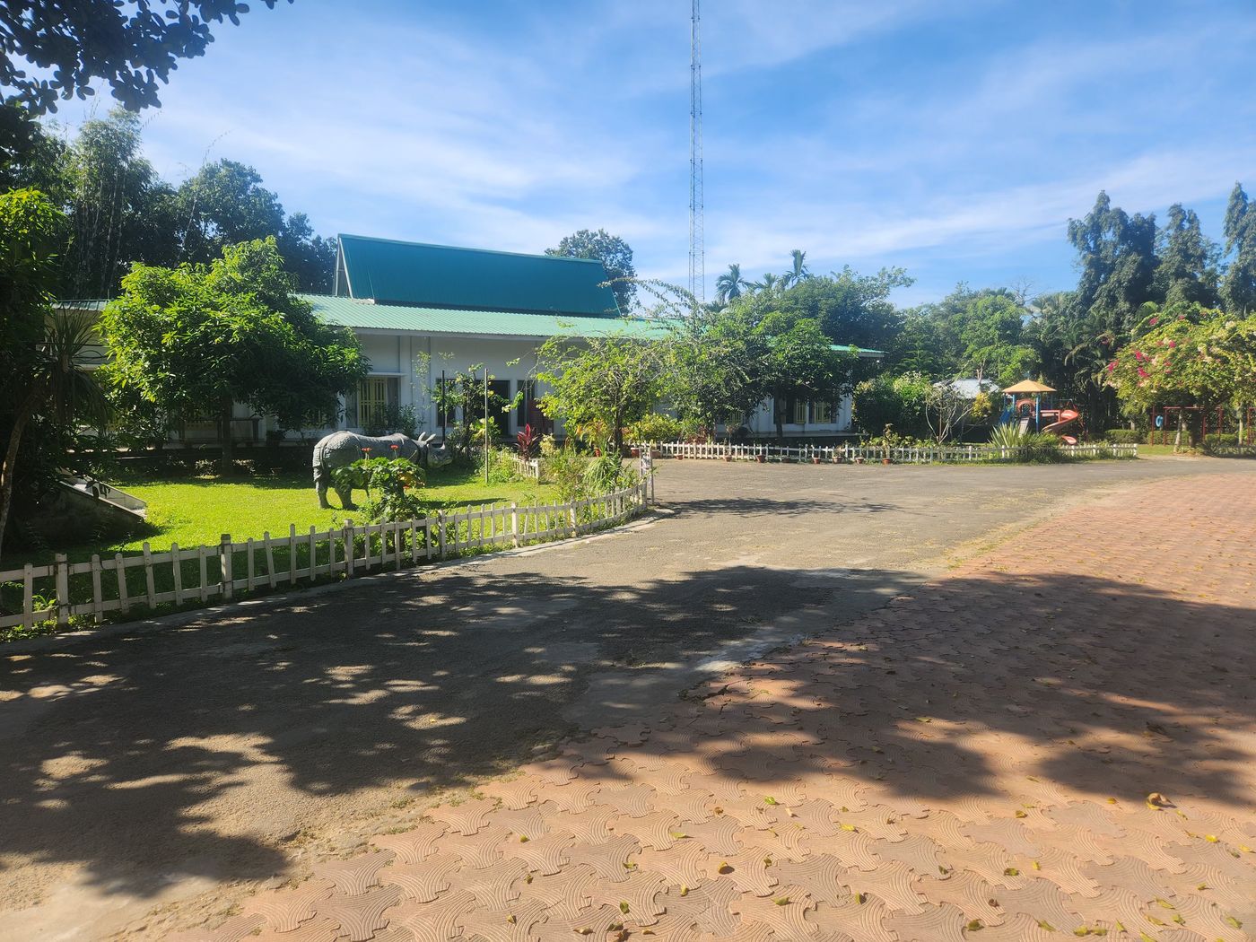 Resort entrance with a one-horned rhino sculpture on the lawn