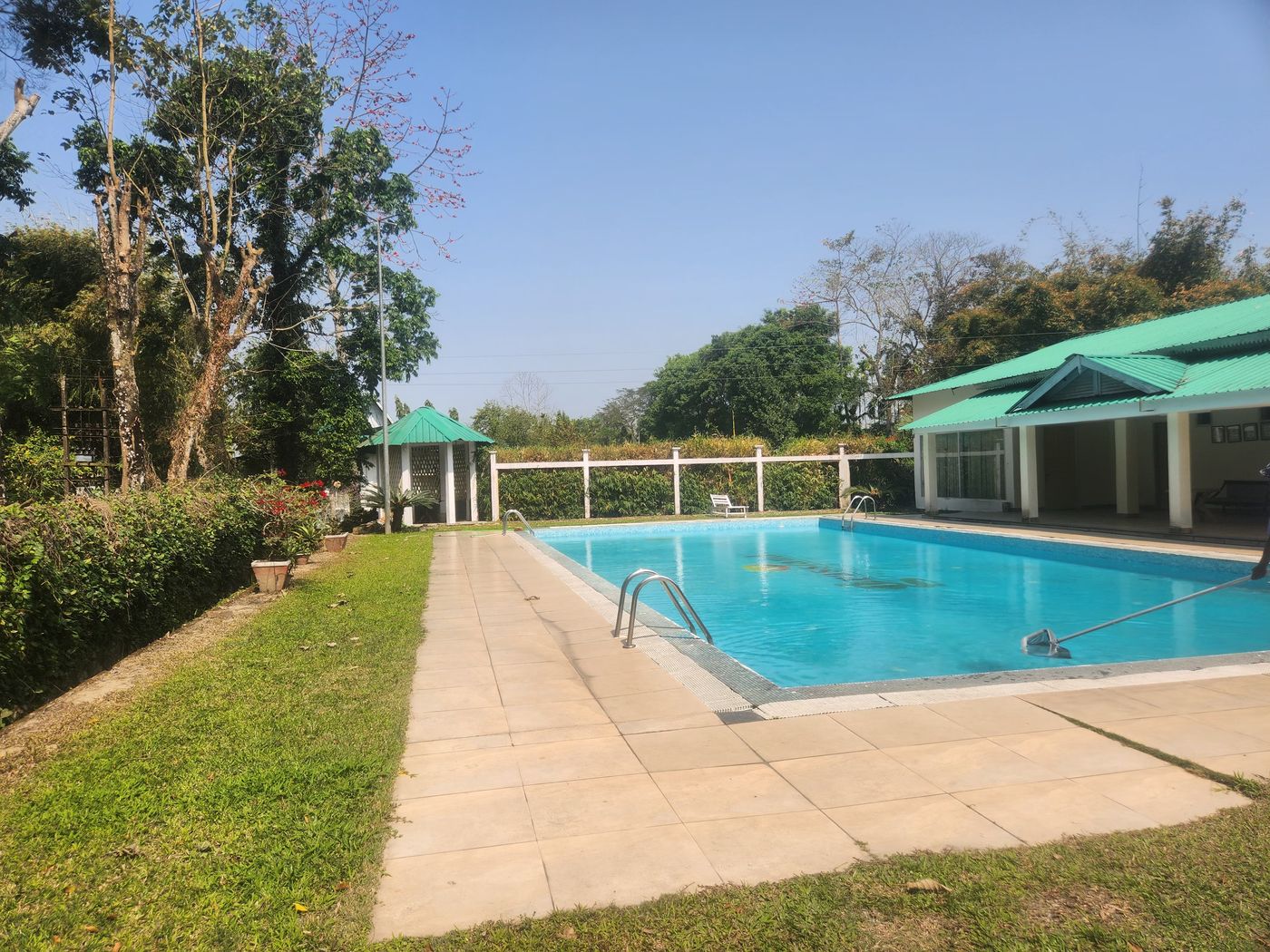 Poolside deck beside the green-roofed pavilion
