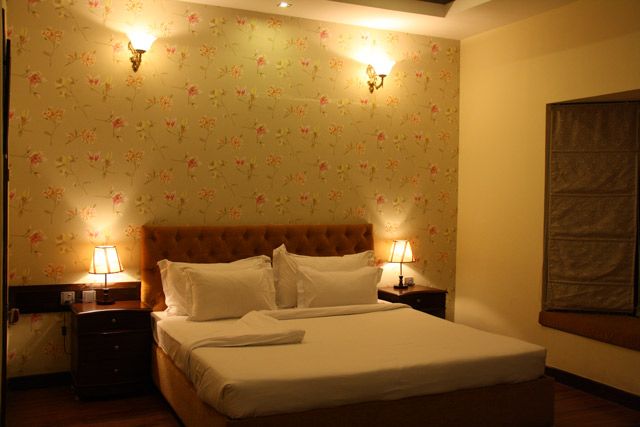 Presidential Suite bedroom with tufted headboard and warm bedside lighting